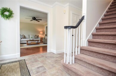 Staircase with crown molding and ceiling fan