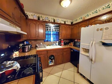 Kitchen featuring a textured ceiling, a sink, ligh