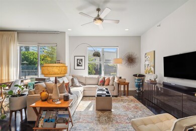 Living room featuring ceiling fan, wood-type flooring, and a healthy amount of sunlight