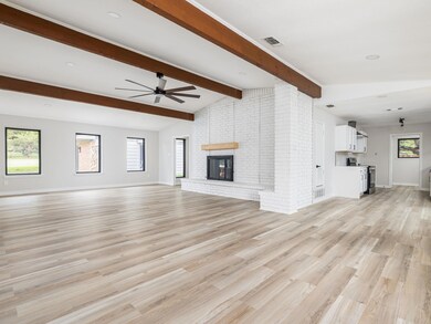Unfurnished living room featuring ceiling fan, li