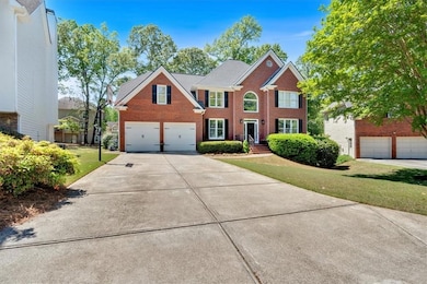 Colonial home with brick siding, an attached garag