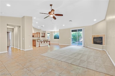 Unfurnished living room with a tiled fireplace, ceiling fan, recessed lighting, and light tile patterned floors