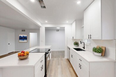 Kitchen featuring sink, white cabinetry, range wit