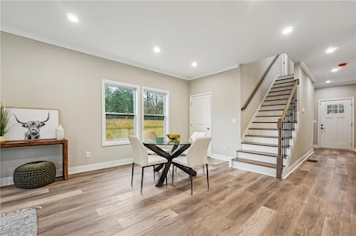 Dining space featuring stairway, light wood-type f