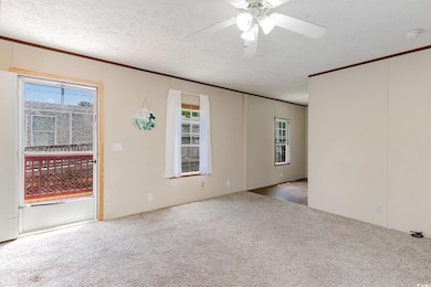 Spare room with crown molding, a textured ceiling,