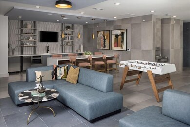 Recreation room with bar with sink, recessed lighting, and tile walls