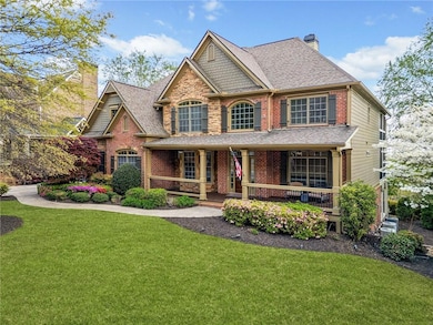 Craftsman inspired home featuring a chimney, a front lawn, brick siding, a shingled roof, and covered porch
