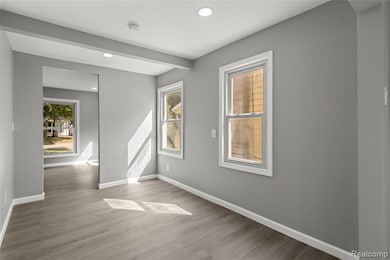 Spare room featuring wood finished floors, recessed lighting, and beamed ceiling