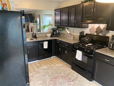 Modern kitchn with black cabinets & appliances.