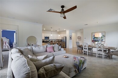 Living area featuring crown molding, ceiling fan,