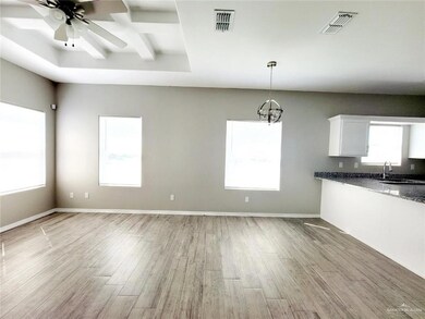Kitchen featuring white cabinetry, light wood-style flooring, visible vents, and a sink
