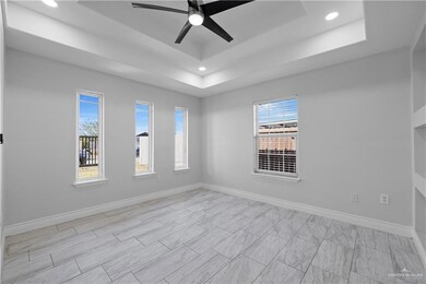 Spare room with ceiling fan and a raised ceiling