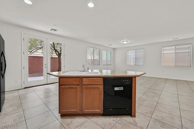 Kitchen featuring black dishwasher, light tile pat