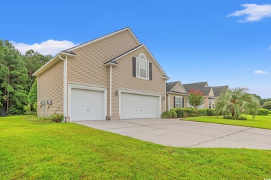 Traditional home featuring a garage, driveway, and a front lawn