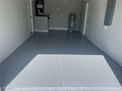 Garage featuring electric panel, electric water he