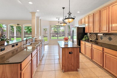Gourmet island kitchen with tile floors, accent tile backsplash, Silestone counters and good amount of storage in the maple cabinets.