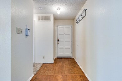 Hall featuring a textured ceiling and hardwood / w