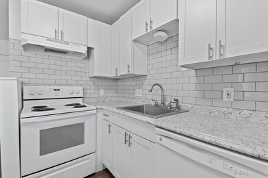 Kitchen featuring white appliances, a sink, under