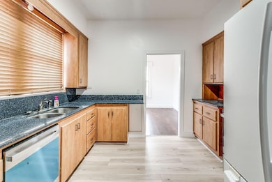 Kitchen with a sink, light wood-style floors, stai
