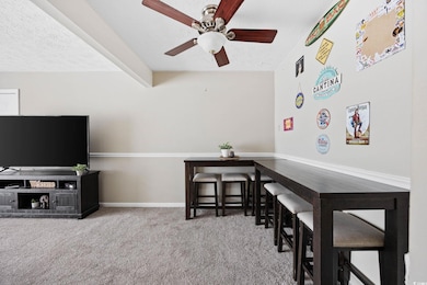 Carpeted home office with a textured ceiling and a ceiling fan