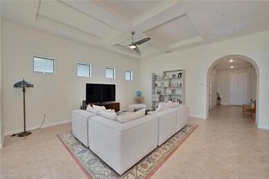 Living room featuring arched walkways, coffered ce