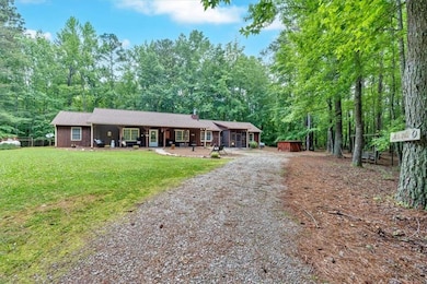 Single story home with dirt driveway, a chimney, and a front yard