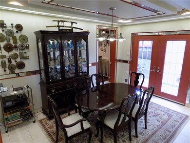 The sunken dining room features a custom tray ceiling with French doors leading to the patio and grill.