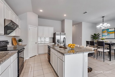 Kitchen with black appliances, white cabinetry, light stone countertops, light tile patterned flooring, and recessed lighting