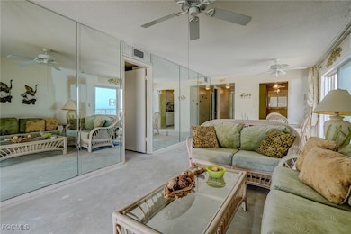 Living room featuring ceiling fan, a textured ceiling, and concrete floors