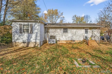 Rear view of property with crawl space and a lawn