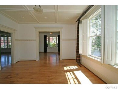 Dining room features a beamed ceiling with medallions, and a triple window that matches the triple windows in the living room and family room.