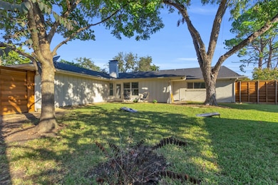 Back of house featuring board and batten siding, a chimney, and brick siding
