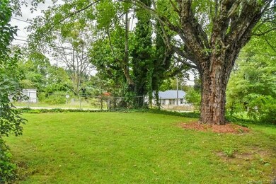 Level front yard, fenced with mature trees