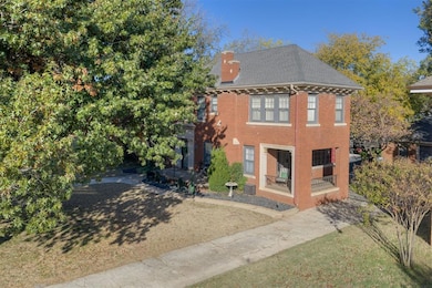 View of front of home featuring a chimney and brick siding
