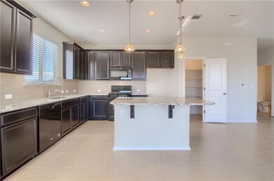 Kitchen with black appliances, light tile pattern