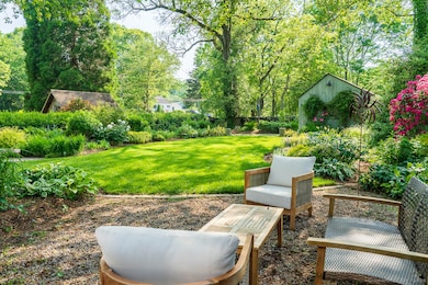 Enjoy the rear yard beauty of border gardens and casual seating.