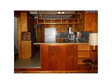 Darling built in bookcase wall leads into the kitc