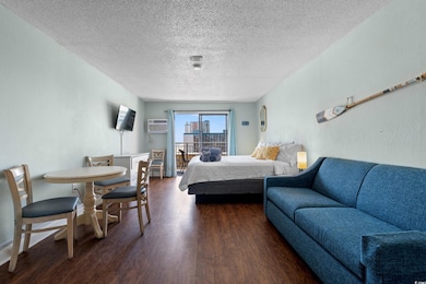 Bedroom with a textured wall, a wall mounted AC, d