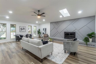 Living room with a skylight, wood-type flooring, a