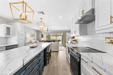 Kitchen featuring a chandelier, under cabinet rang