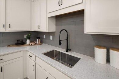 Kitchen with white cabinetry, a sink, and decorati