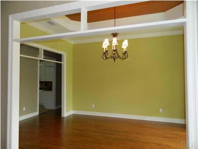 Formal dining room wiht decorative ceiling and chandelear.