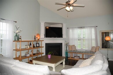 Living room with fireplace and vaulted ceiling.