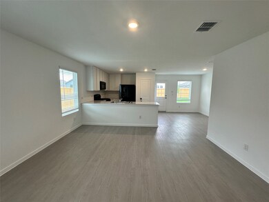 Unfurnished living room with wood finished floors, visible vents, recessed lighting, and baseboards