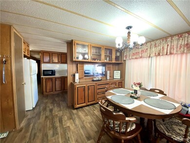 Dining area with dark wood-style floors, a chandelier, and a textured ceiling
