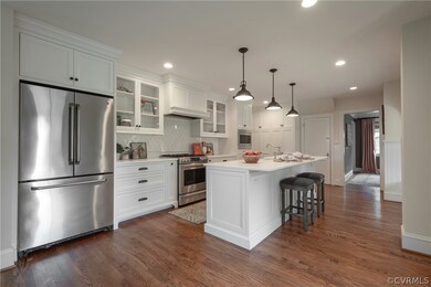 Kitchen with white cabinets, dark hardwood / wood-