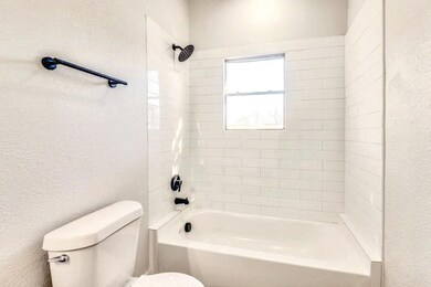 Bathroom featuring tiled shower / bath and toilet