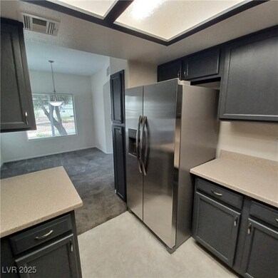 Kitchen featuring light carpet, visible vents, lig