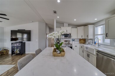 Kitchen with light stone counters, recessed lighti