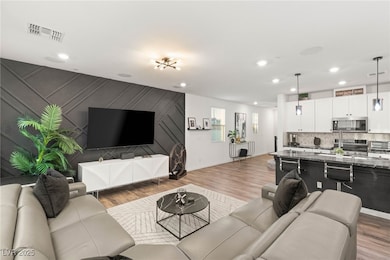 Living area with wood finished floors, recessed li